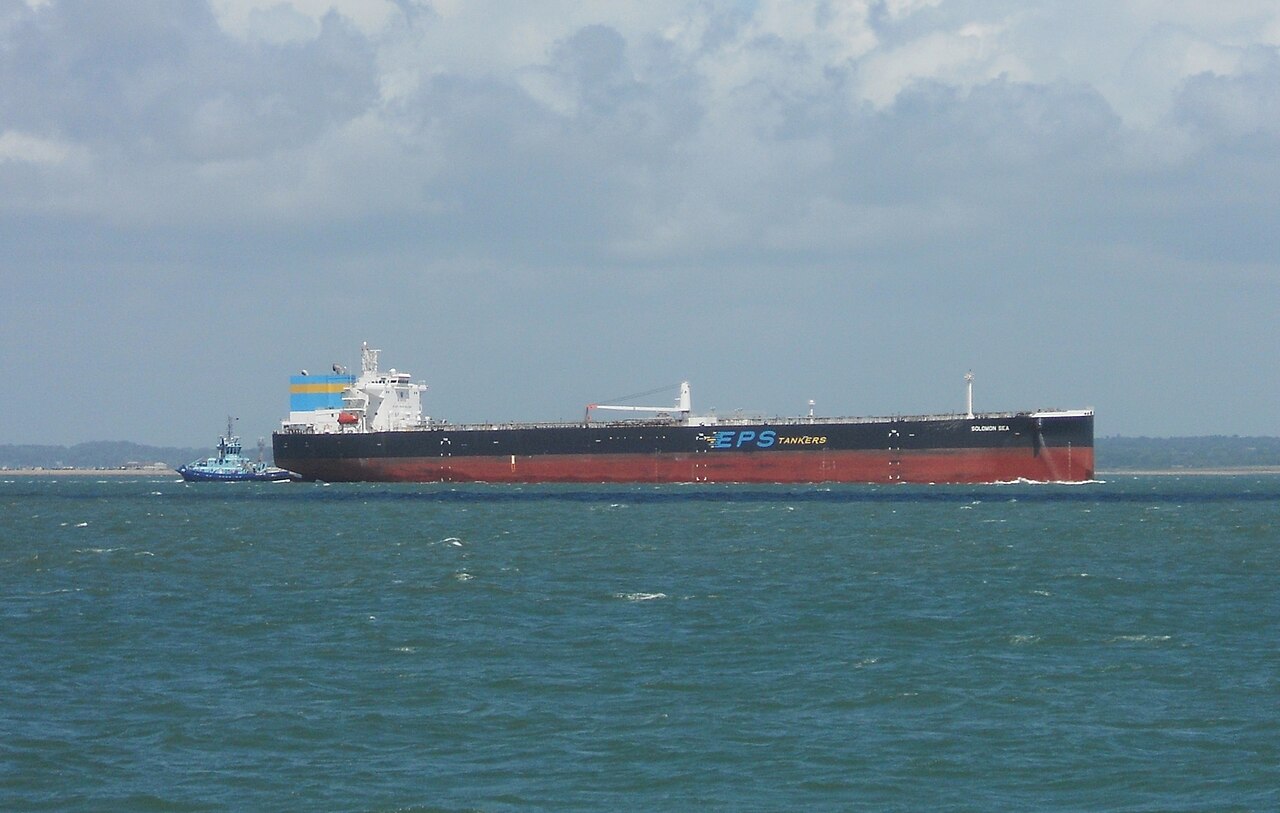 A large oil tanker labeled EPS Tankers navigating at sea with a tugboat alongside