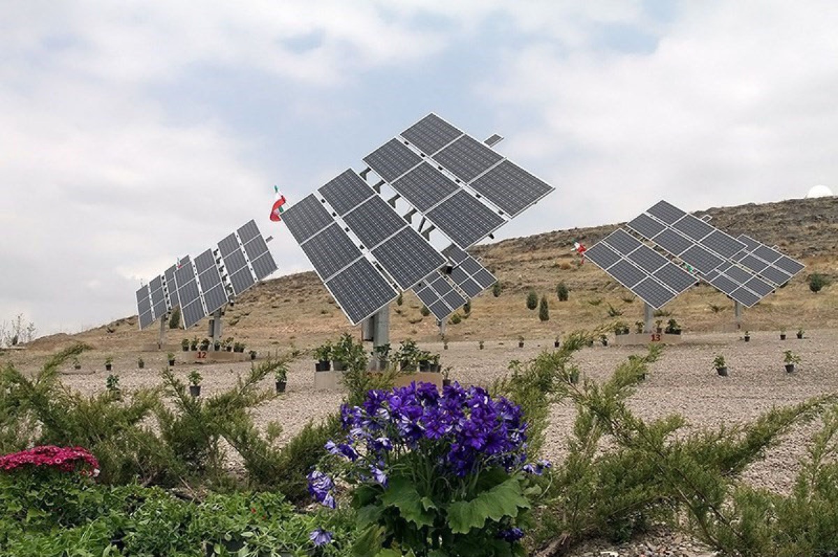 Solar panels at the Mashhad solar power plant in Iran, with arid hills in the background